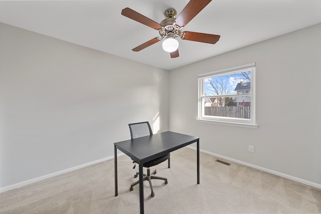 unfurnished office featuring visible vents, baseboards, carpet, and a ceiling fan