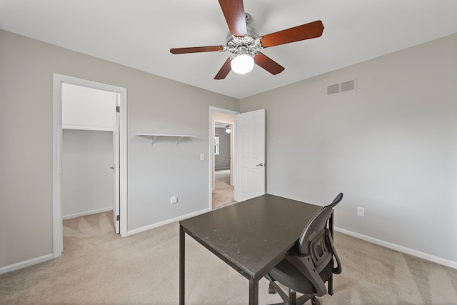 office space featuring ceiling fan, light colored carpet, visible vents, and baseboards