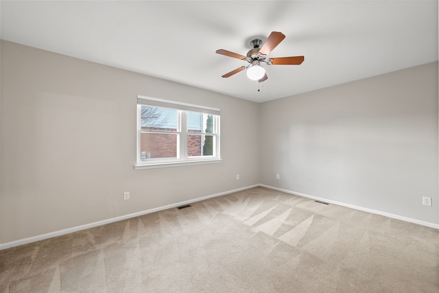 carpeted empty room featuring visible vents, baseboards, and ceiling fan