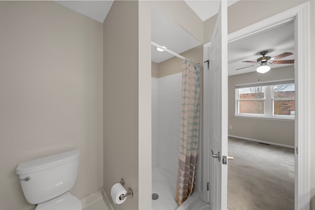 full bathroom featuring a shower stall, toilet, baseboards, and a ceiling fan