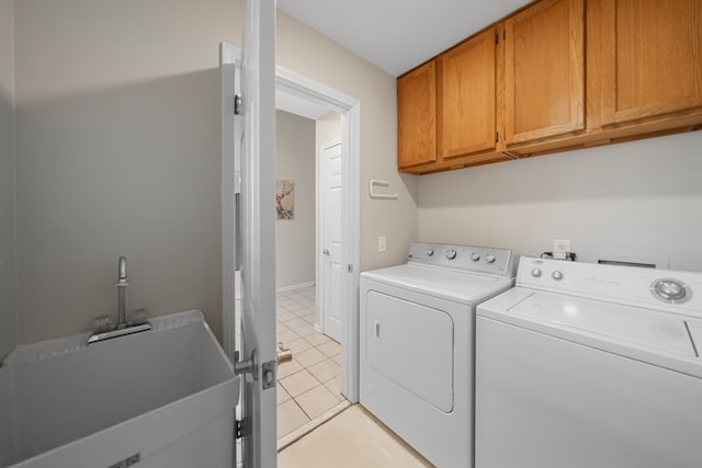 washroom featuring light tile patterned floors, cabinet space, independent washer and dryer, and a sink