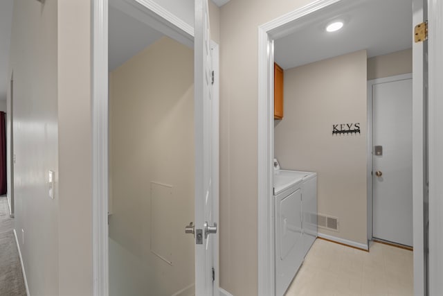 laundry room featuring washing machine and clothes dryer, visible vents, cabinet space, and baseboards