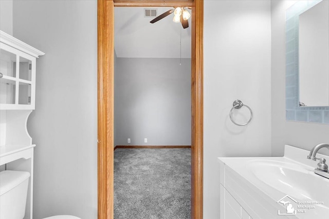 bathroom with visible vents, baseboards, ceiling fan, toilet, and vanity