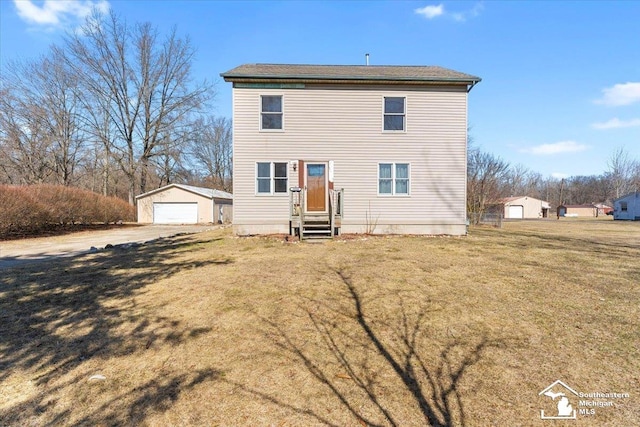 rear view of house with an outdoor structure, a yard, and a garage