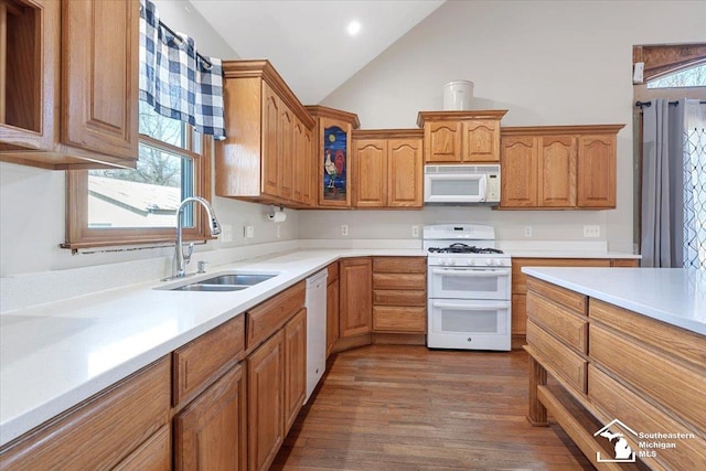 kitchen with white appliances, light countertops, dark wood-style flooring, and a sink