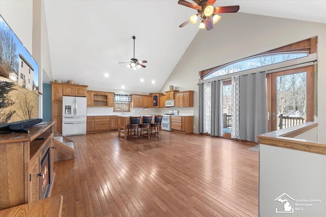 interior space with wood-type flooring, high vaulted ceiling, and a ceiling fan