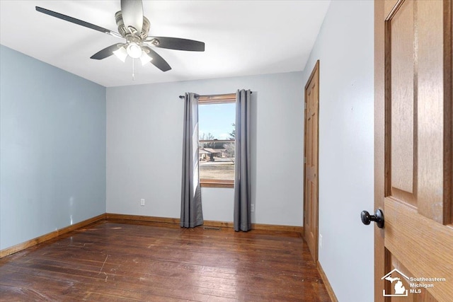 empty room featuring ceiling fan, baseboards, and wood-type flooring