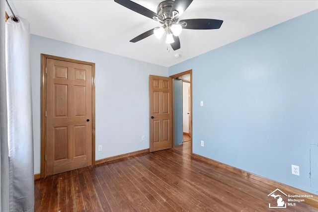 unfurnished bedroom with a ceiling fan, wood finished floors, and baseboards