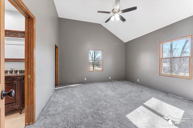 carpeted empty room with a sink, lofted ceiling, and ceiling fan