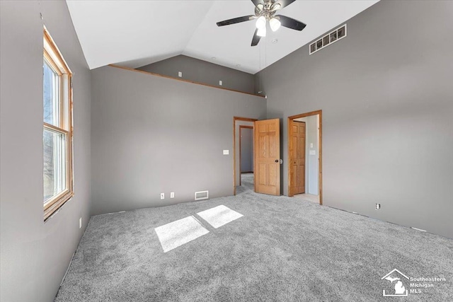 carpeted empty room featuring visible vents, a healthy amount of sunlight, and a ceiling fan