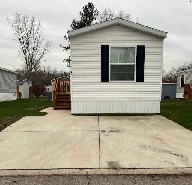 view of side of property featuring a yard and a wooden deck