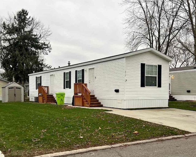 manufactured / mobile home featuring a storage shed, an outbuilding, and a front yard