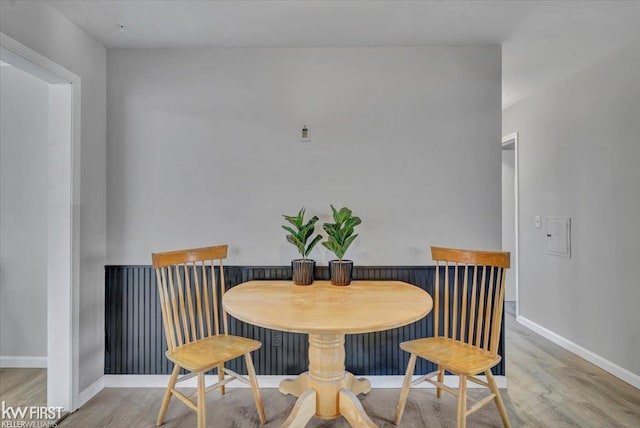 dining area with baseboards and wood finished floors