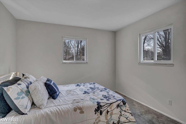 bedroom with carpet flooring, multiple windows, and baseboards