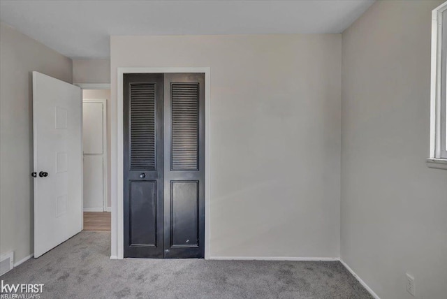 unfurnished bedroom featuring visible vents, baseboards, a closet, and carpet flooring