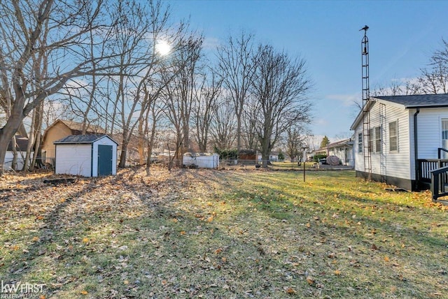 view of yard with a storage unit, an outdoor structure, and fence