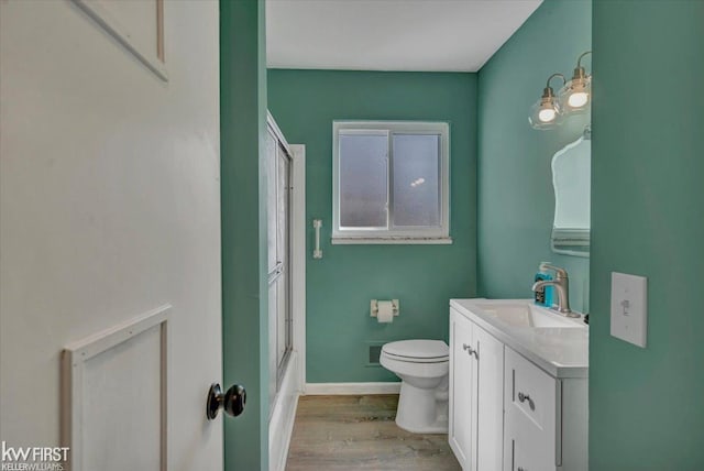 bathroom with vanity, wood finished floors, visible vents, baseboards, and toilet