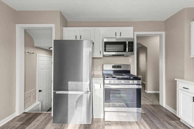 19124 Harman St, Melvindale, MI 48122 - kitchen with white cabinetry, stainless steel appliances, baseboards, and wood finished floors