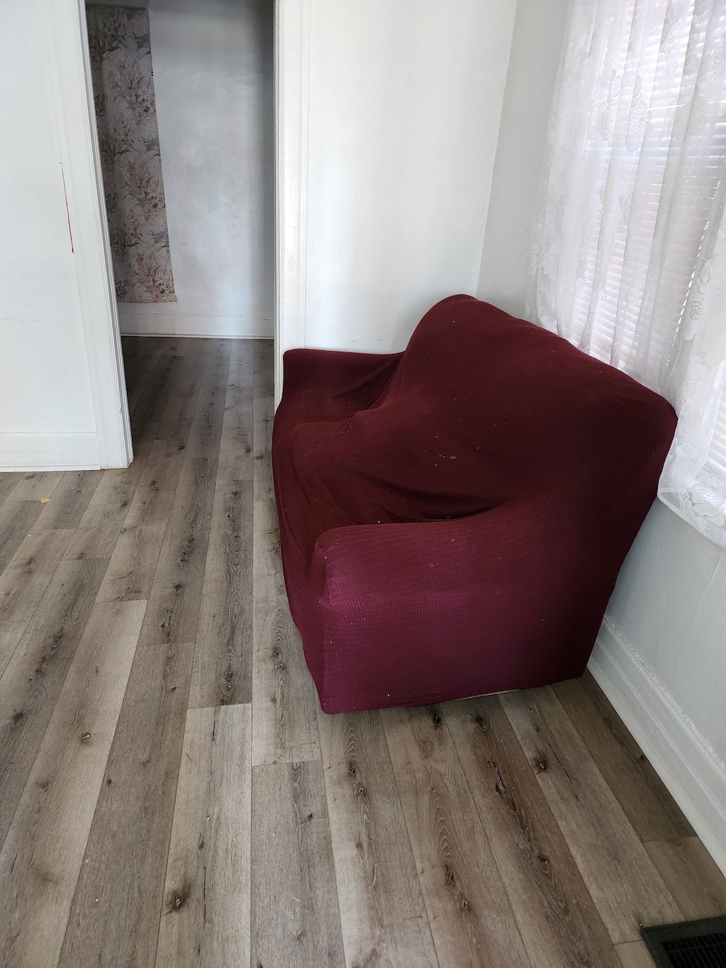 living area with visible vents, baseboards, and hardwood / wood-style floors