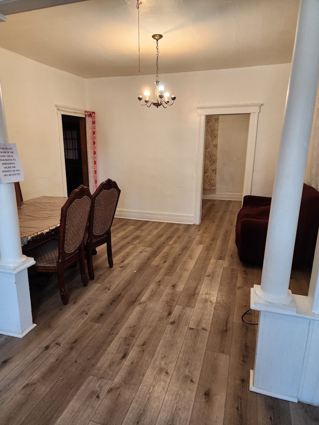 dining room featuring hardwood / wood-style flooring, baseboards, and a chandelier