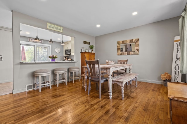 dining space featuring recessed lighting, baseboards, and hardwood / wood-style flooring