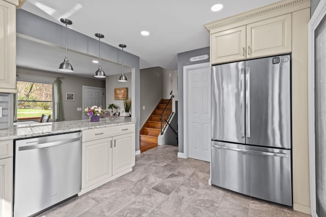 kitchen with pendant lighting, appliances with stainless steel finishes, light stone counters, recessed lighting, and cream cabinetry