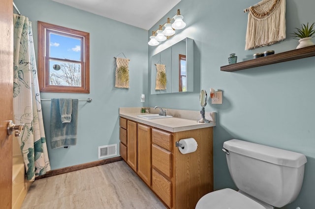 bathroom with visible vents, vanity, wood finished floors, curtained shower, and toilet