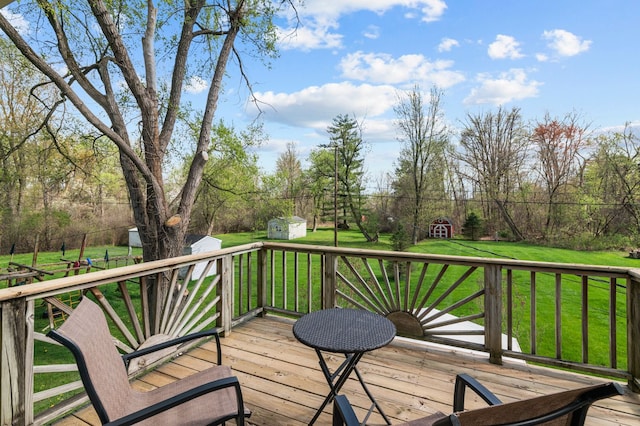 deck with a lawn, an outbuilding, and a shed