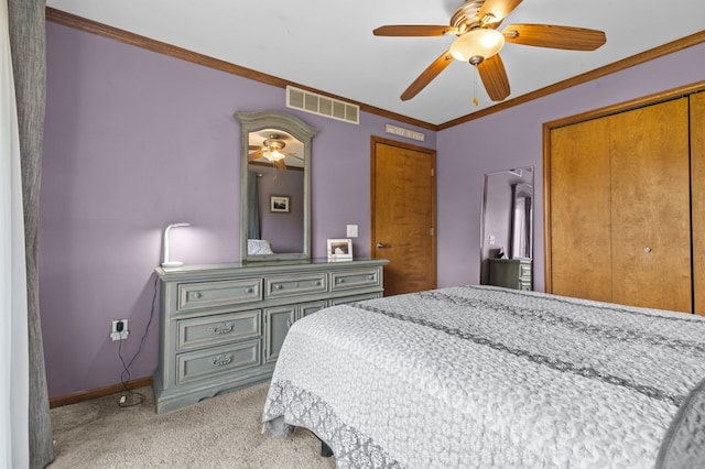 bedroom featuring light colored carpet, baseboards, visible vents, ornamental molding, and a closet