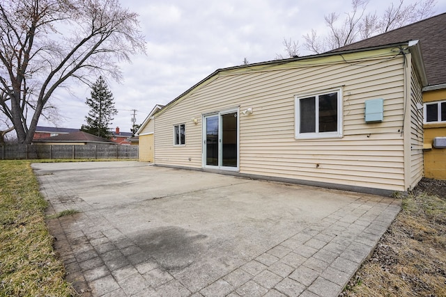 rear view of property featuring fence and a patio area