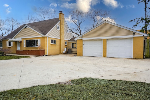 view of home's exterior with cooling unit, an outdoor structure, a shingled roof, brick siding, and a chimney