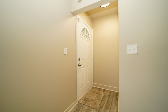 doorway to outside featuring baseboards and light wood-style floors