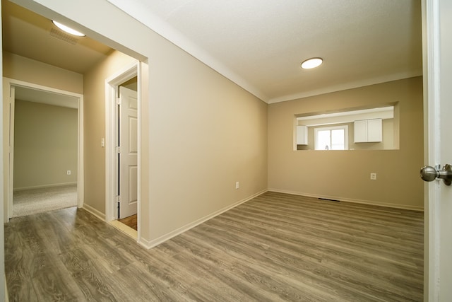 unfurnished room featuring visible vents, baseboards, and wood finished floors