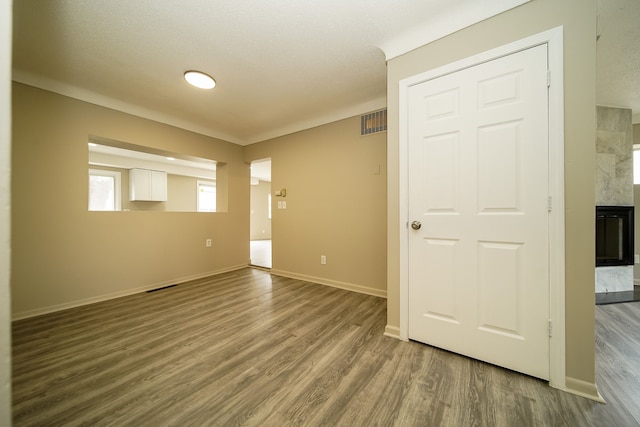 unfurnished room featuring visible vents, baseboards, and wood finished floors