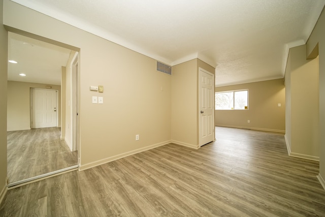 spare room featuring recessed lighting, visible vents, baseboards, and wood finished floors