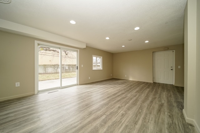 unfurnished room featuring recessed lighting, light wood-type flooring, and baseboards