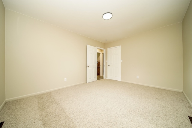 empty room with light colored carpet and baseboards