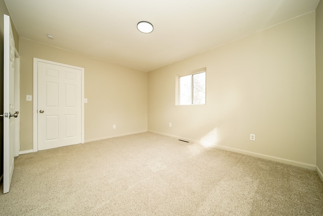 carpeted spare room with baseboards and visible vents