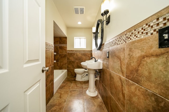 full bath featuring visible vents, a sink, tile walls, toilet, and tile patterned floors