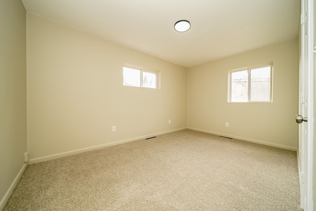 unfurnished room featuring light carpet, visible vents, and baseboards