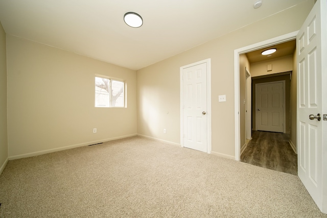 carpeted empty room with baseboards