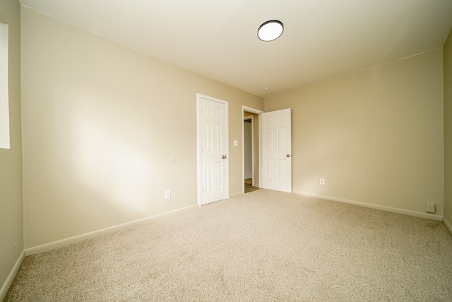 unfurnished room featuring baseboards and carpet