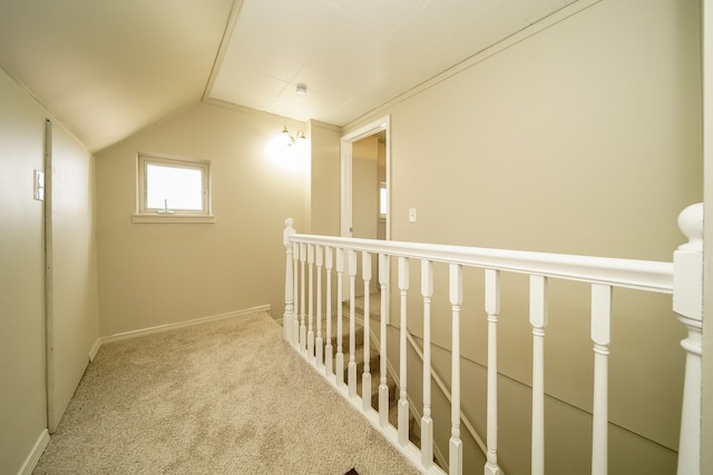 corridor featuring vaulted ceiling, baseboards, and carpet floors