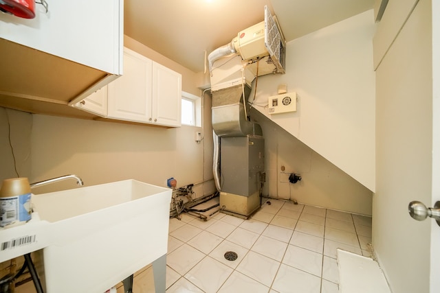 laundry area featuring a sink, heating unit, and light tile patterned floors