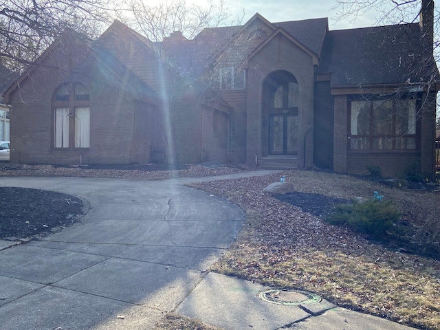 view of front of home featuring brick siding and a chimney