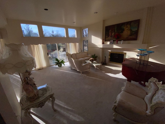 carpeted living room with a glass covered fireplace