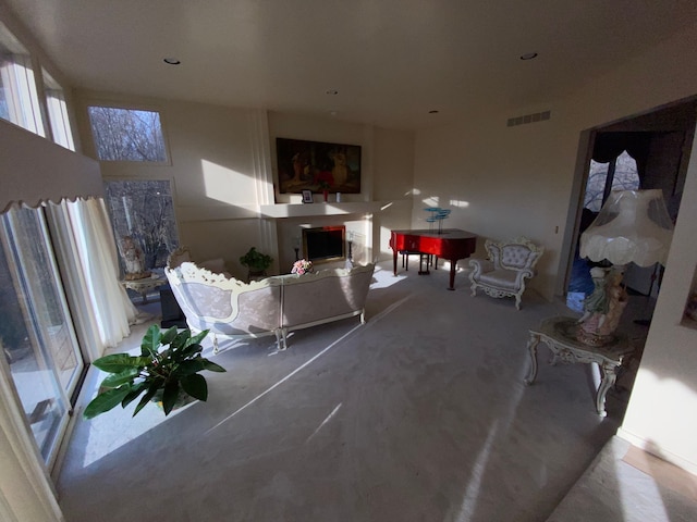 living room with a fireplace, visible vents, and concrete flooring