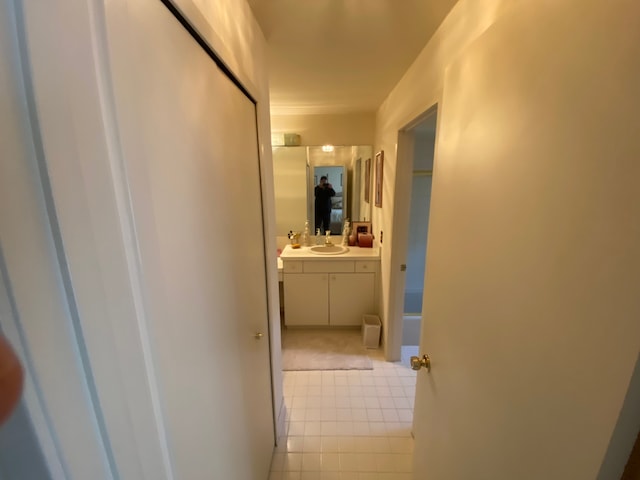 corridor with light tile patterned floors and a sink