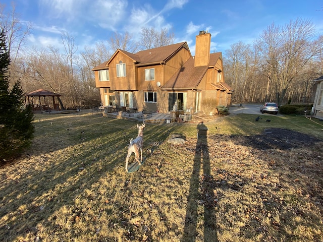 back of house featuring a gazebo, a patio area, and a chimney