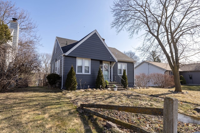 bungalow with a front lawn and roof with shingles